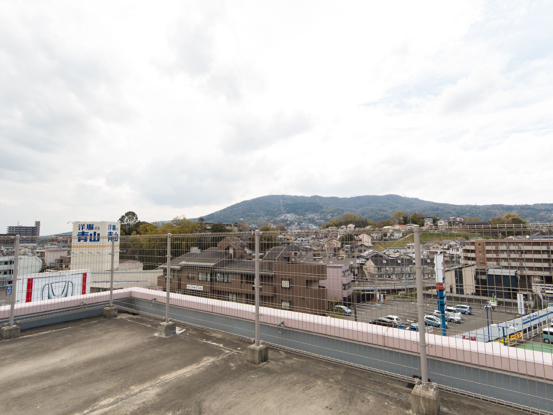 遠くに山を望める、住宅街に立つ建物の屋上からの景色