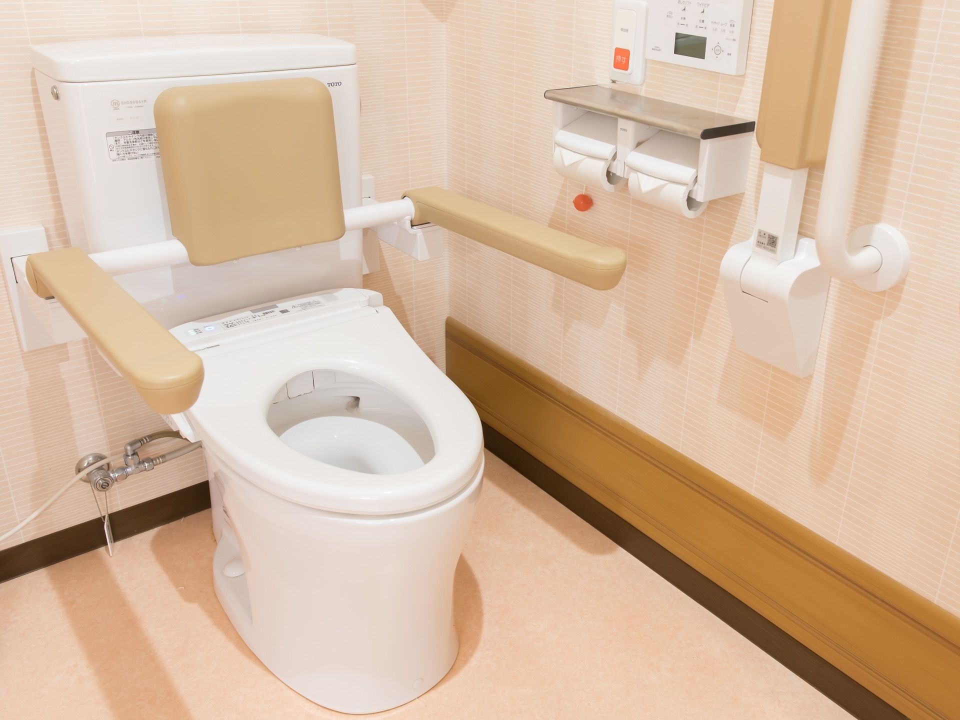 車椅子対応の広々としたトイレである。便器の左右、そして壁に折りたたみ可能な手すりが付けられている
