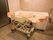 淡いピンク色の壁、ベージュのタイル床に施工された機械浴室である。広々とした介護浴槽、専用のリフターが置かれている。