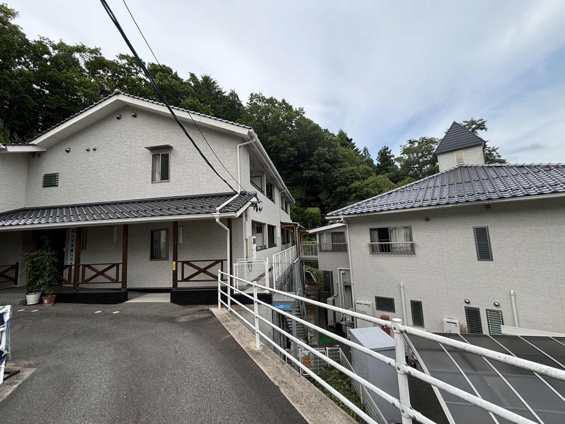 車椅子に乗った高齢女性と隣りに寄り添う女性ヘルパー