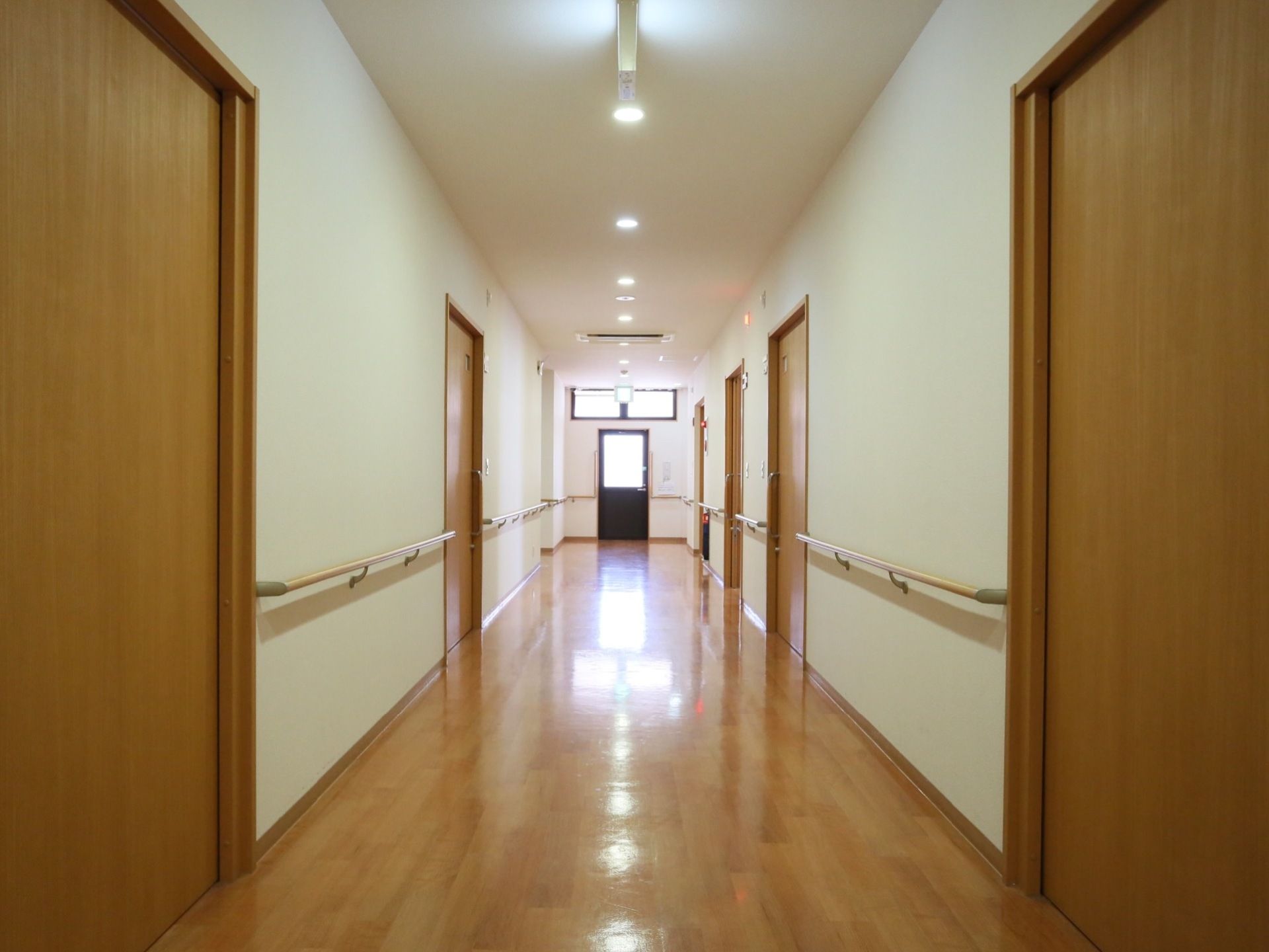 清潔感のある白い壁が美しい廊下である。清掃が行き届いた床はピカピカに輝いている。手すりや非常口を誘導する表示が完備されている。