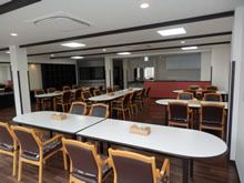 キッチン付きのリビングダイニングにはティッシュ箱が置かれたダイニングテーブルが複数設置されている。