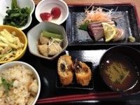 たくさんのお皿が並ぶ黒いトレー。汁物や炊き込みご飯、刺身などが置かれている。