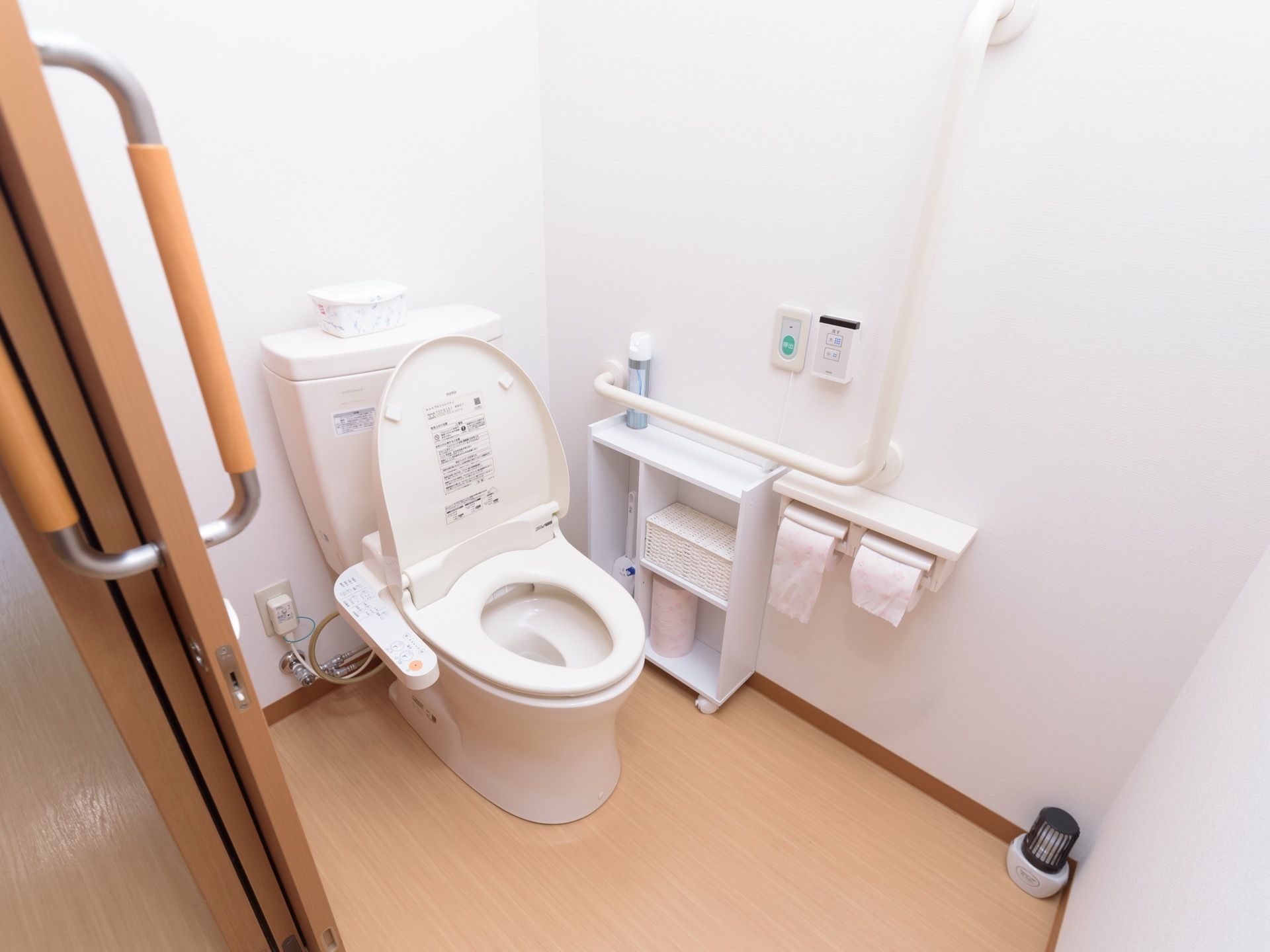スライド式の扉で仕切られている個室トイレである。横には収納棚が設置されており、予備のペーパーが置いてある。