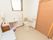 洗面台が備え付けられている広々としたトイレである。温水洗浄便座が採用されており、壁には呼び出しボタンがある。