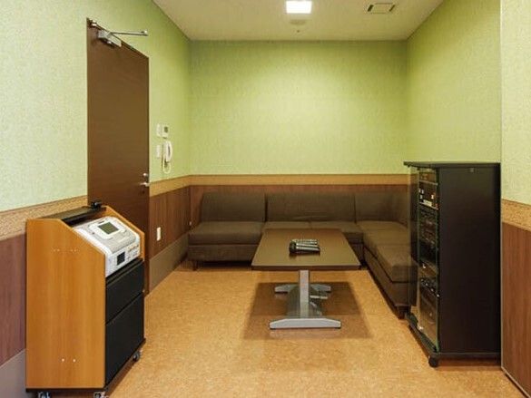 エル字型のブラウンのソファやテーブルが置かれた部屋には本格的なカラオケ設備がある。