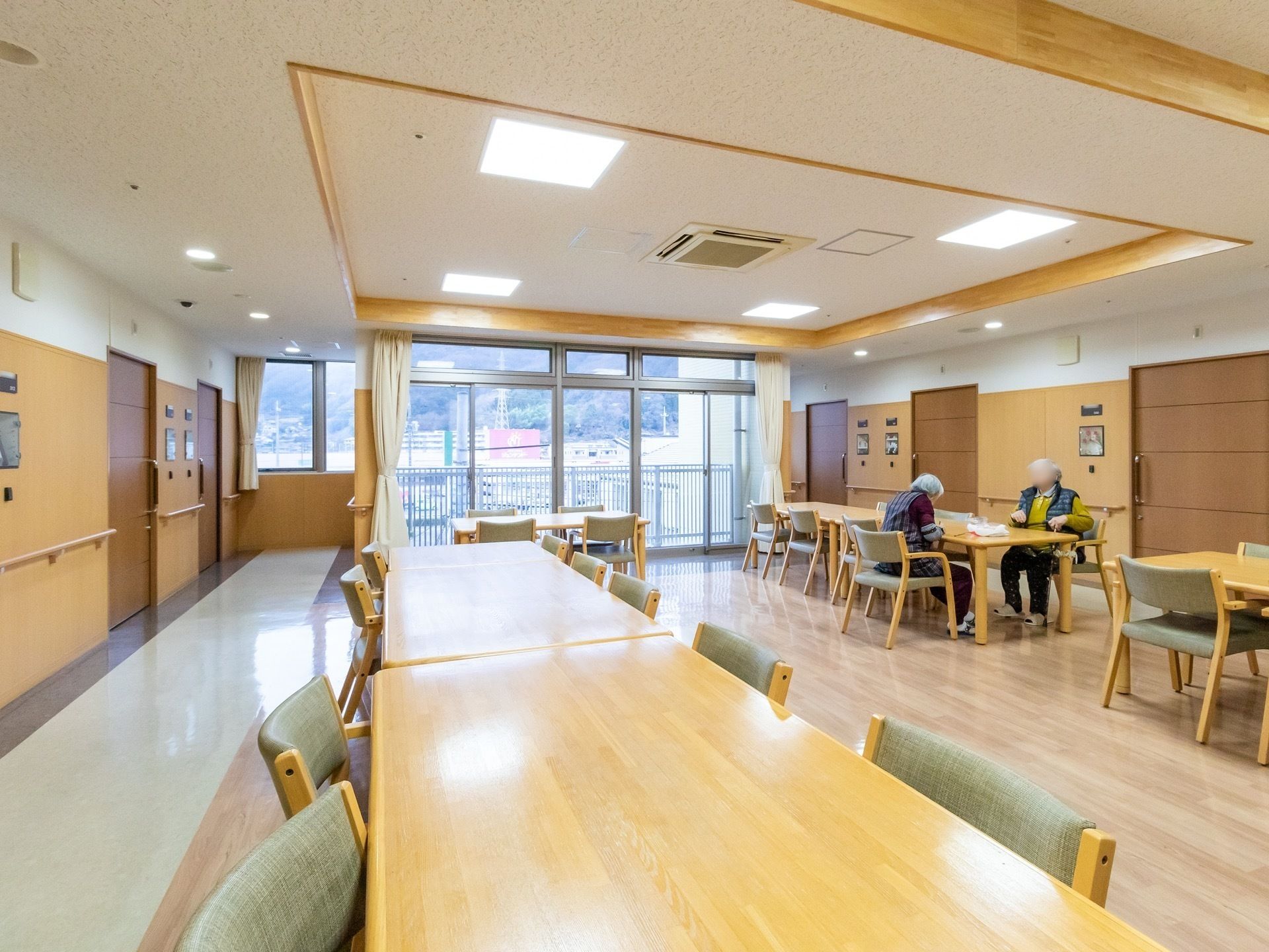 部屋全体に手すりが付いており、テーブルと椅子が並んでいる居室