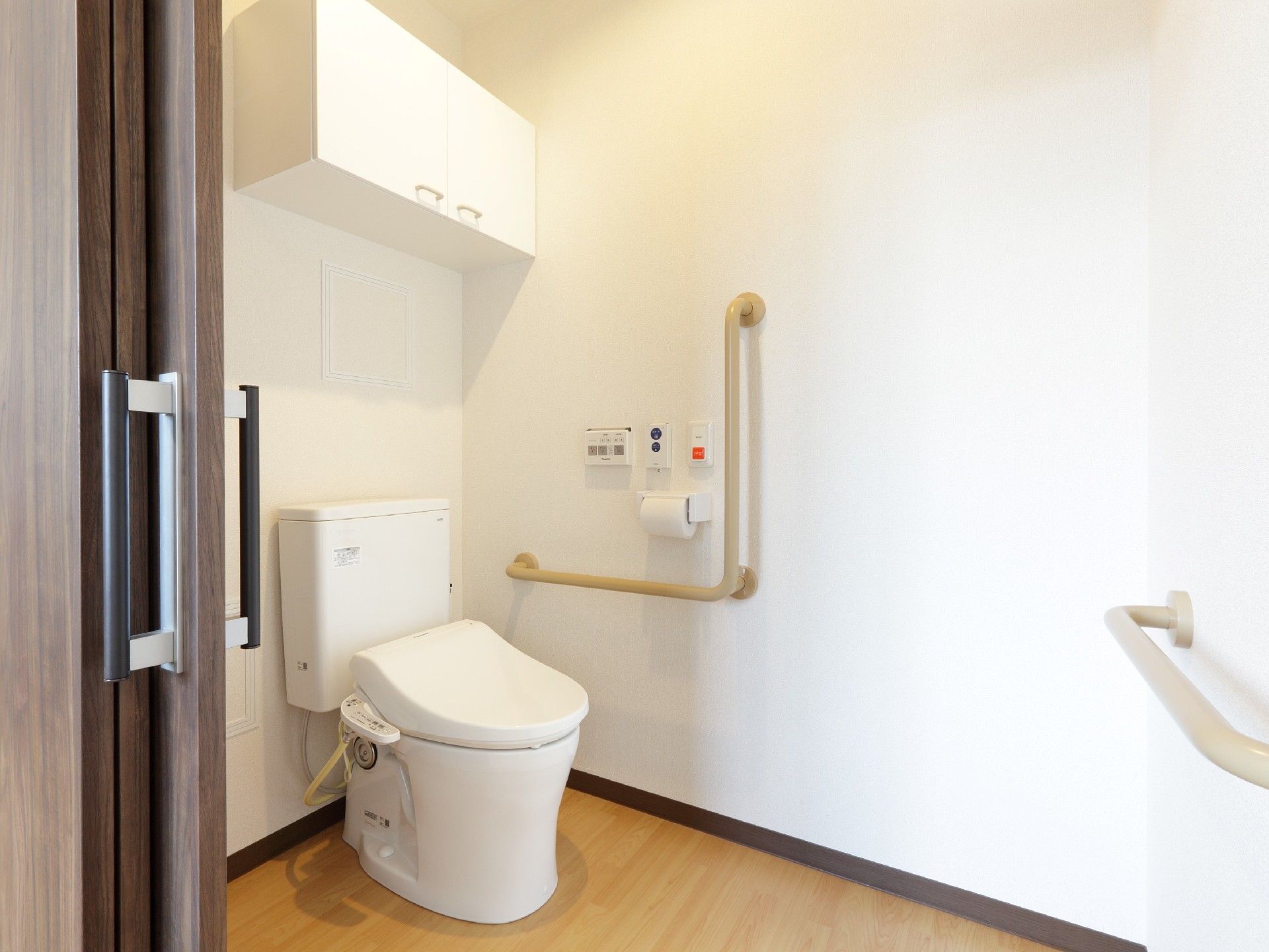 シンプルなトイレには手すりが付き、車いす対応の広さを確保。呼び出しボタンも付いている。