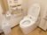 温水洗浄機能付き便座が採用されているトイレで、壁には手すりやナースコール、ペーパーホルダーや操作パネルが設置されている。