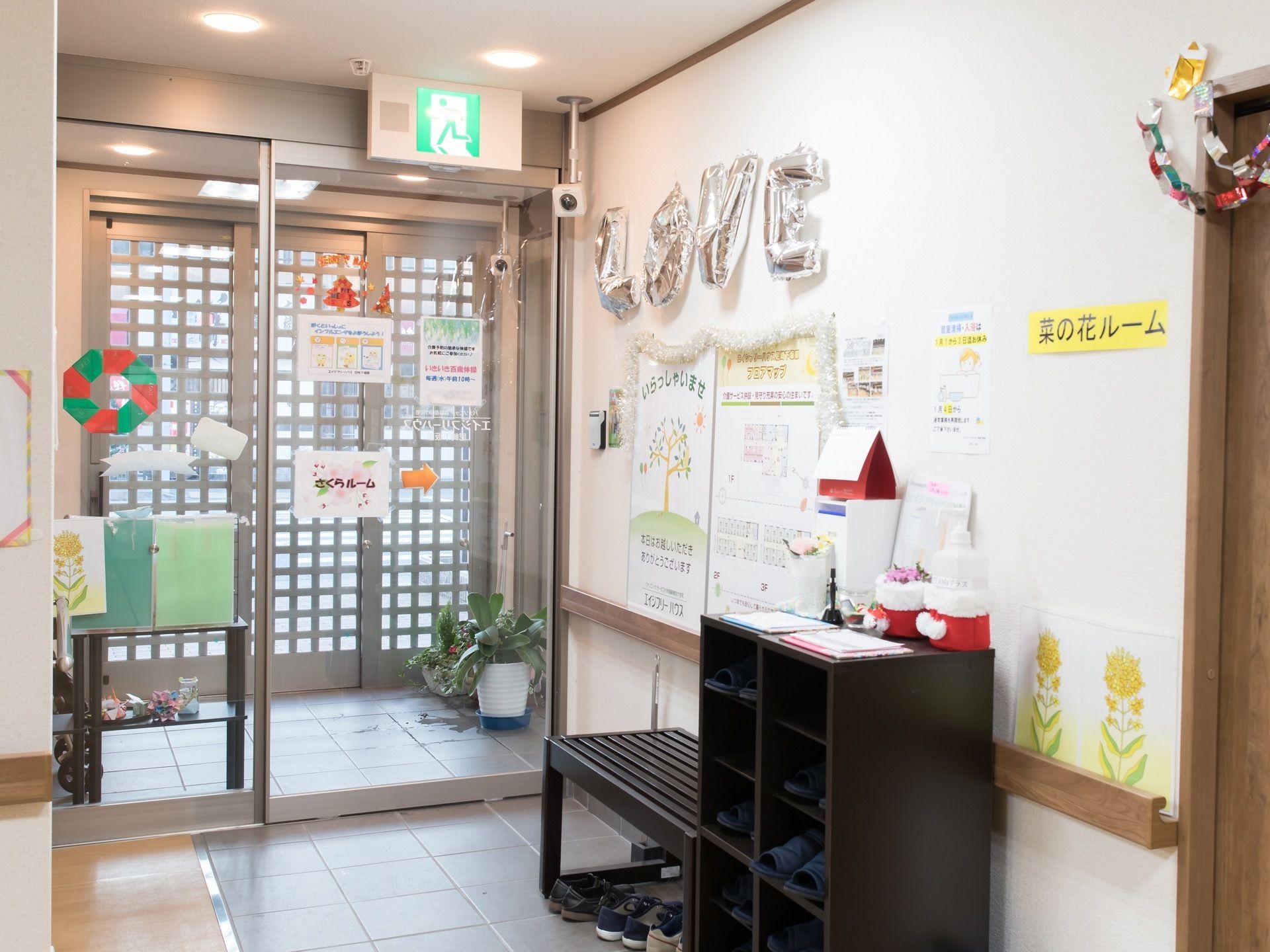 館内履き用のスリッパが収納されている靴箱の横に、ベンチが設置されている。フロアの随所に、手作りの装飾が施されている。