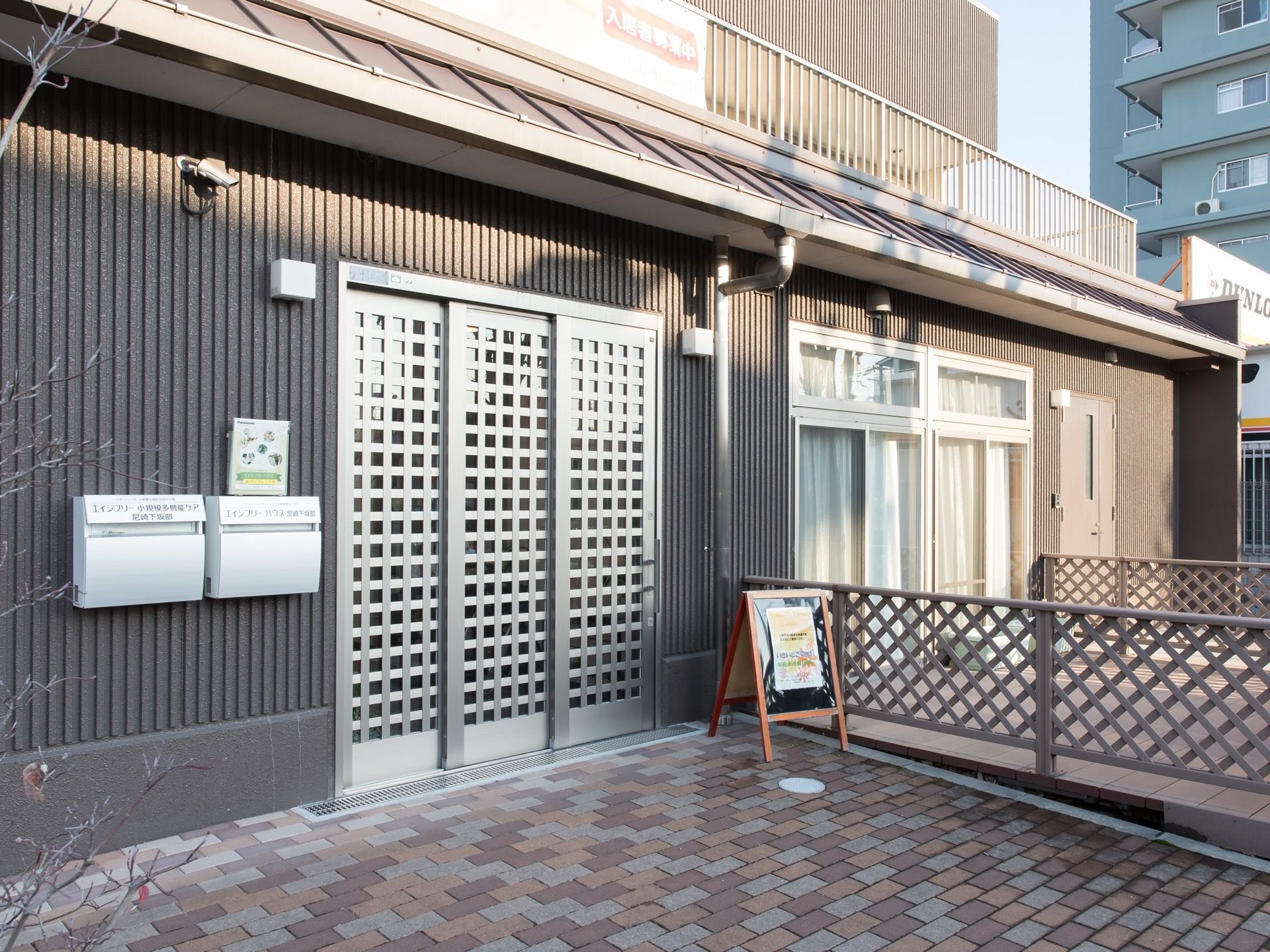 スタイリッシュな外観の建物である。入口はスライド式の扉が採用されており、横の壁には郵便ポストが設置されている。