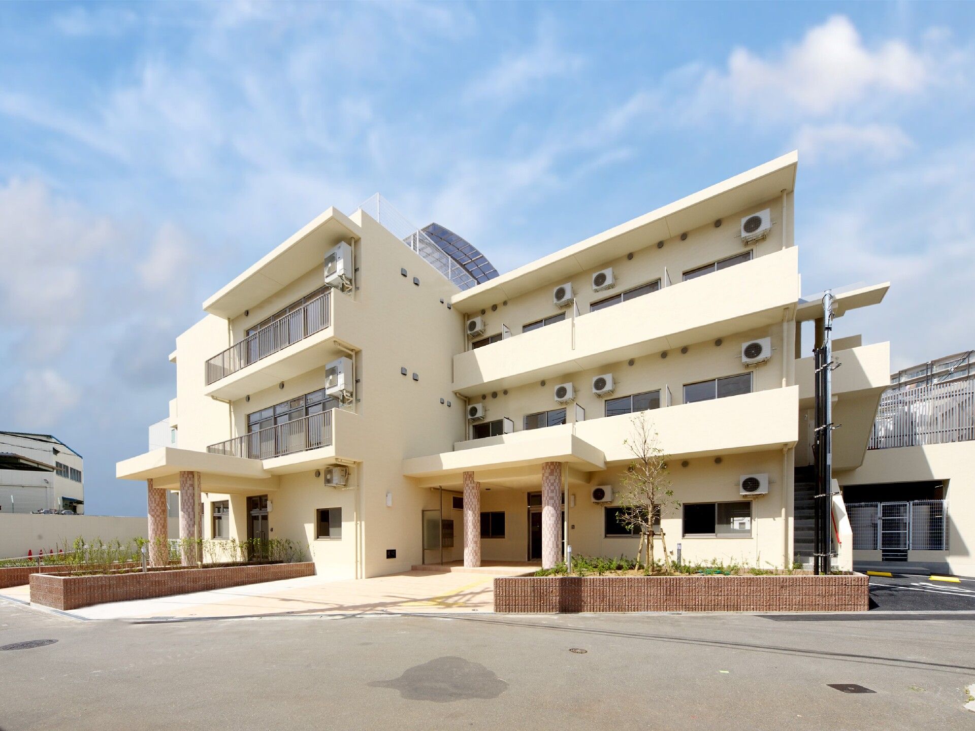白の3階建てのマンションのような建物