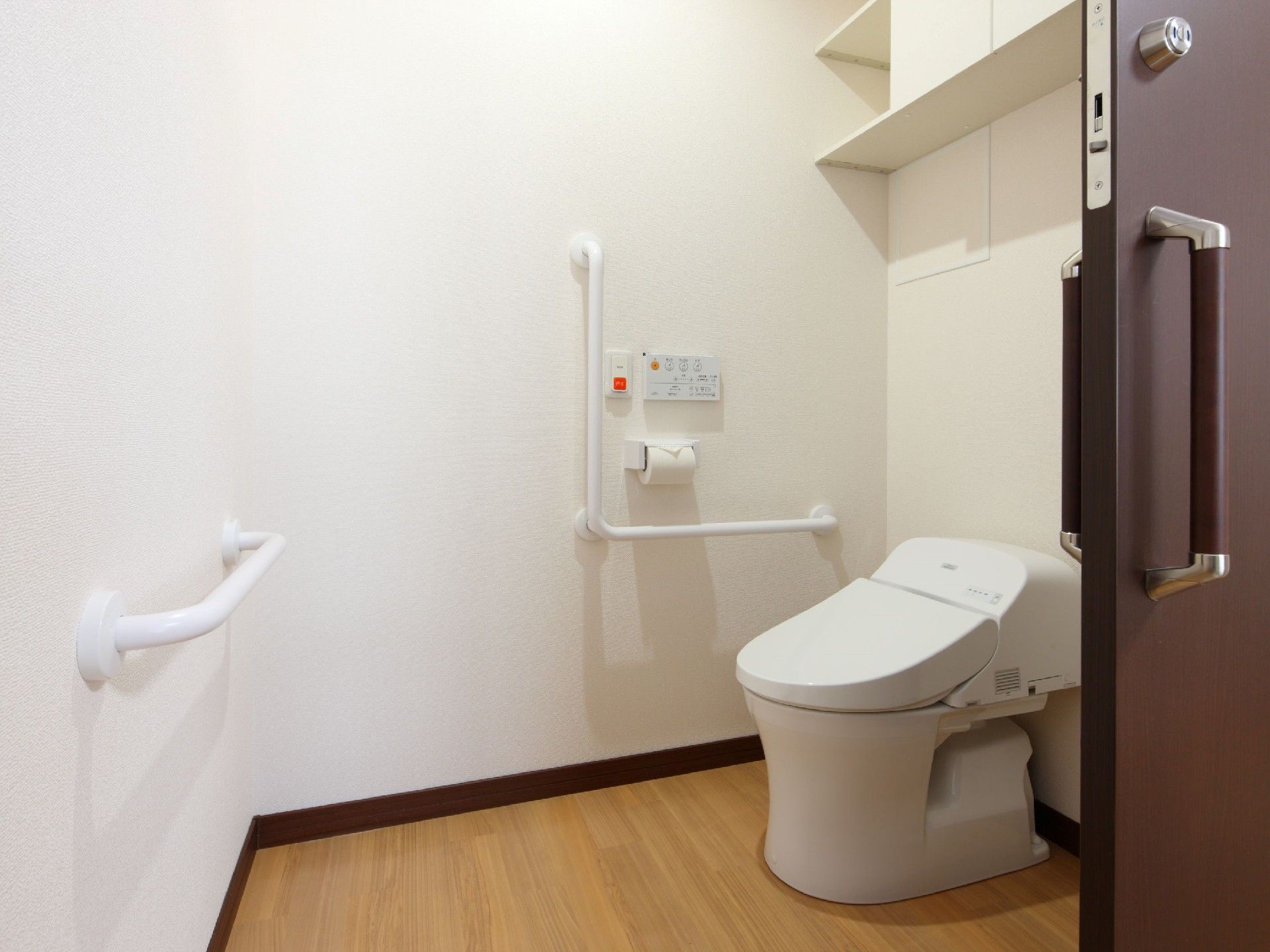 介助スペースも十分あるトイレには手すりが複数付き、オレンジ色の呼び出しボタンもある。