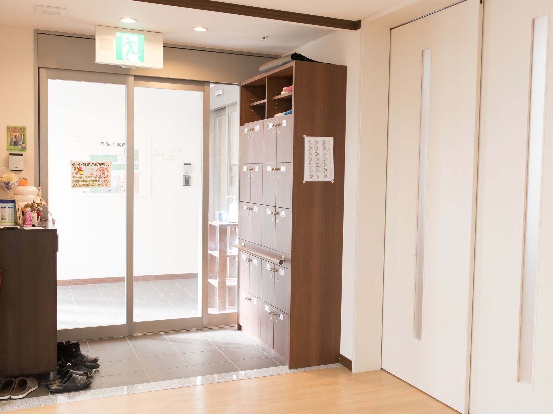 エントランスのドアはガラスの自動ドアが設置されている。左右には靴箱が設置され、居住スペースに入る前に靴を履き替えるようになっている。