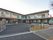 エル字型の２階建ての建物はモノトーン。玄関は自動ドアで、駐車スペースが広い。