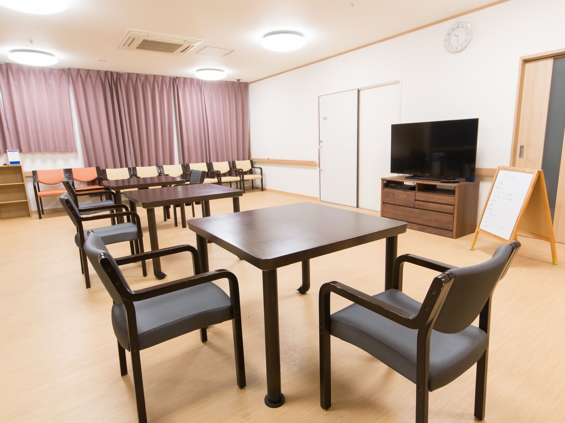 天井に空調の付いた広いフロアがある。テーブルセットが並べられており、壁際にはテレビも設置されている。