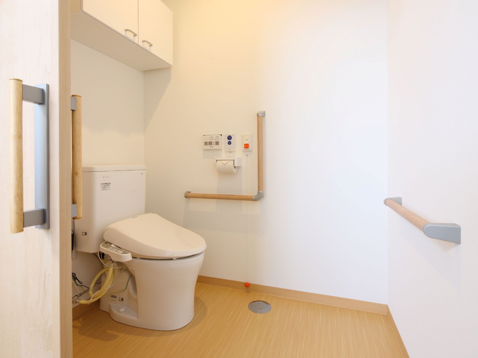 手すりや呼び出しボタンが付いたトイレは広く、シンプルな造り。