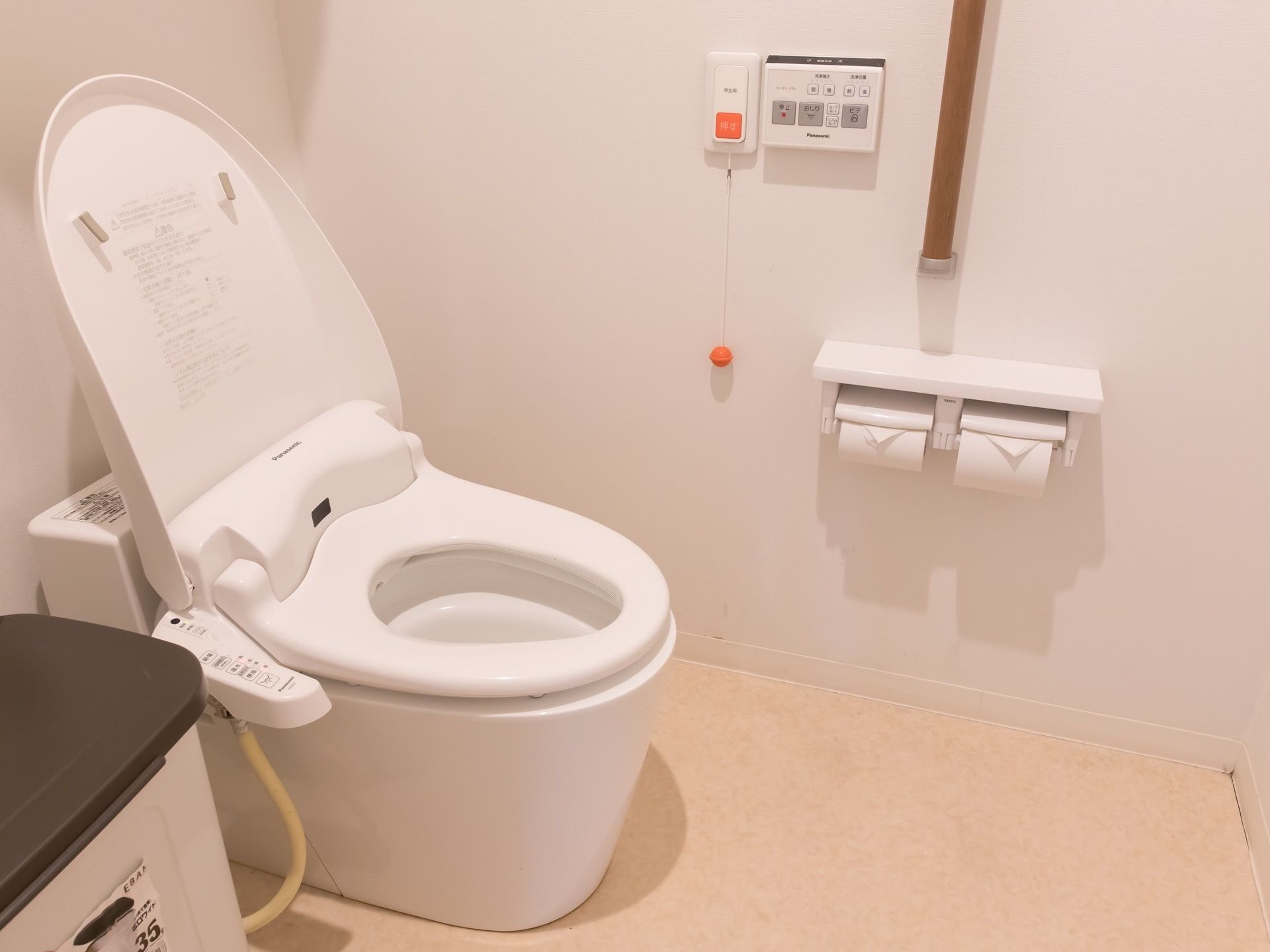 トイレには緊急呼び出しボダンがついている。白色の明るい個室に茶色の木目調手すりが目立ってわかりやすい。