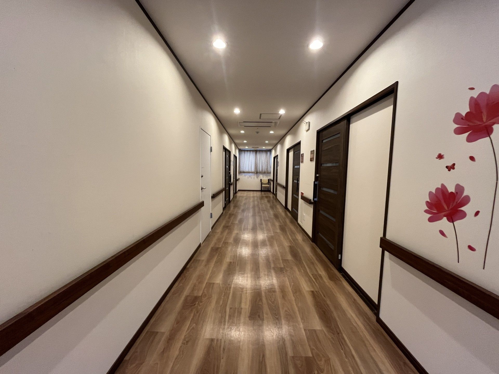 家具が置かれていないシンプルな居室。フローリングでトイレや洗面所、緊急通報装置が付いている。