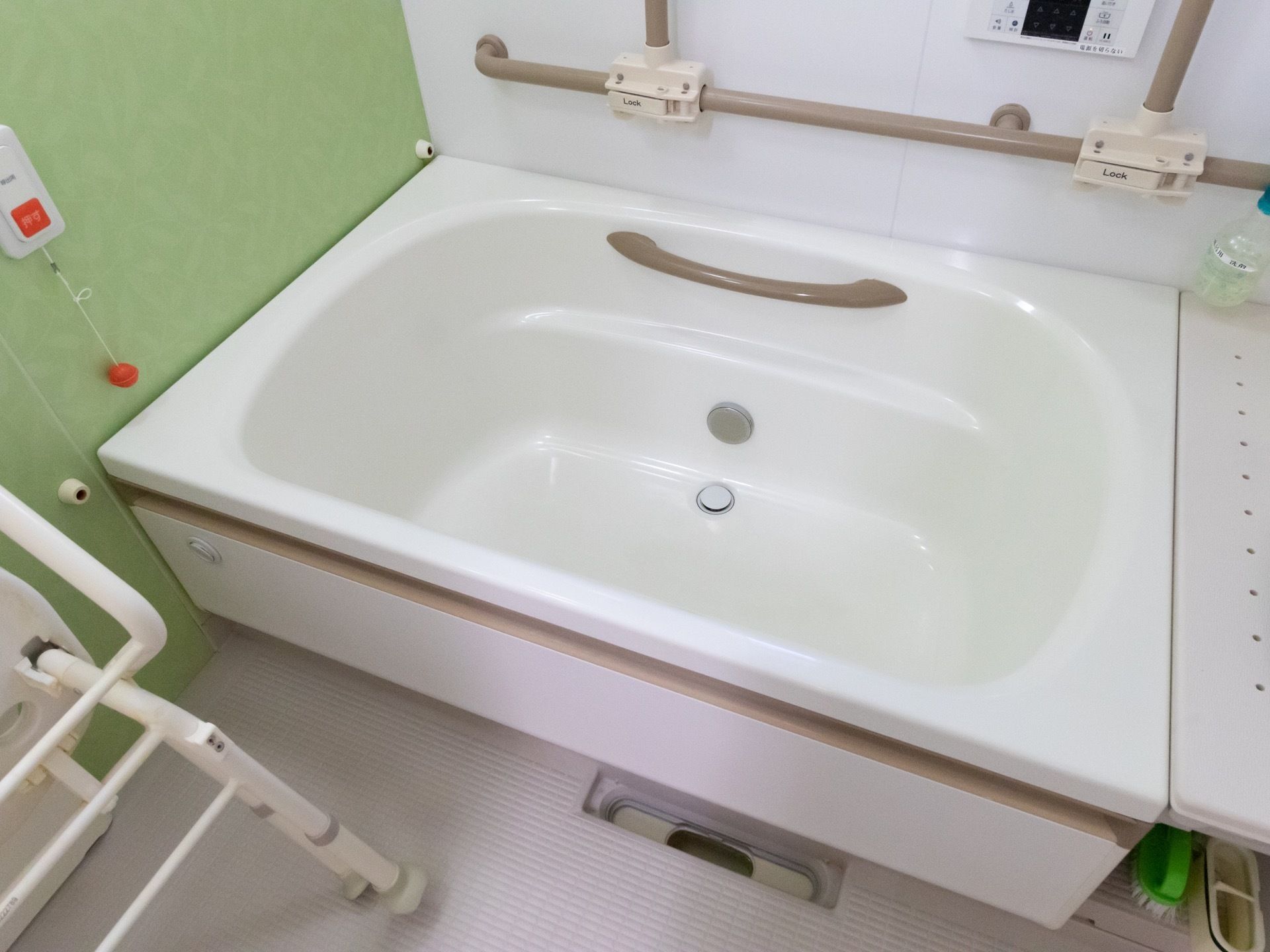 浴室の床は滑り止めの加工が施されている。手すりやシャワーチェアが完備されており、起き上がりをスムーズにできる。