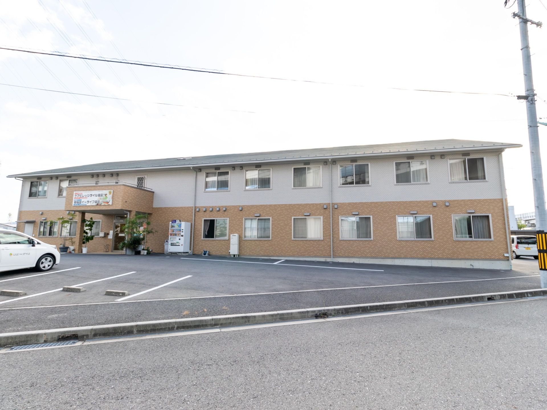 施設は２階建てで窓が多い。大きな建物が周りにないので日当たりが良い。道路に面し、大きな駐車場が完備されている。