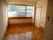 大きな窓が付いた明るい部屋。家具や家電は置かれていない。壁には緊急通報装置がある。
