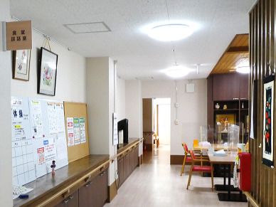 アクリル板が設置されているダイニングテーブルが置かれた食堂。壁にはお知らせが貼られている。