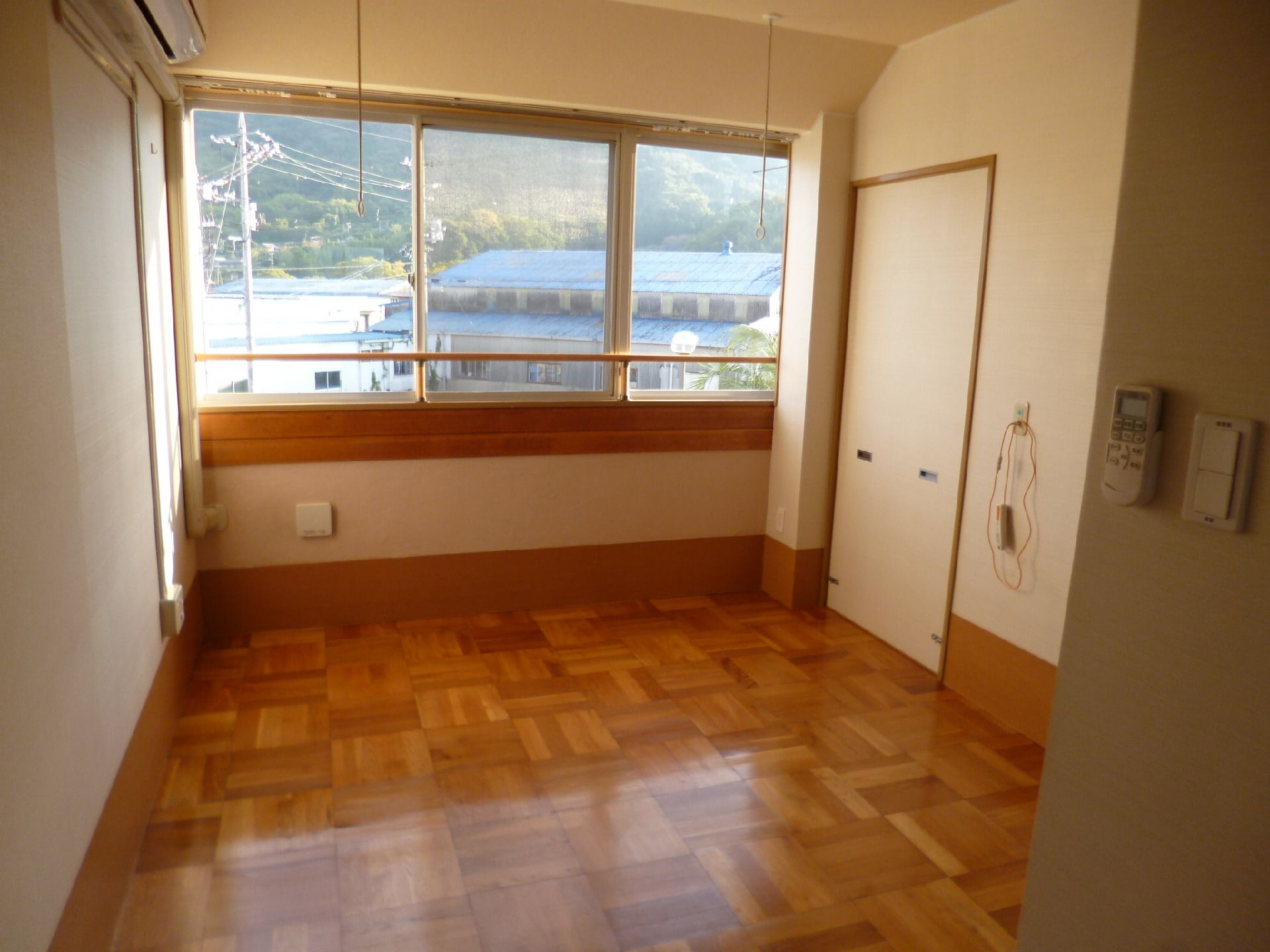 フローリングの部屋には大きな窓があり、カーテンはない。壁には緊急通報装置もある。