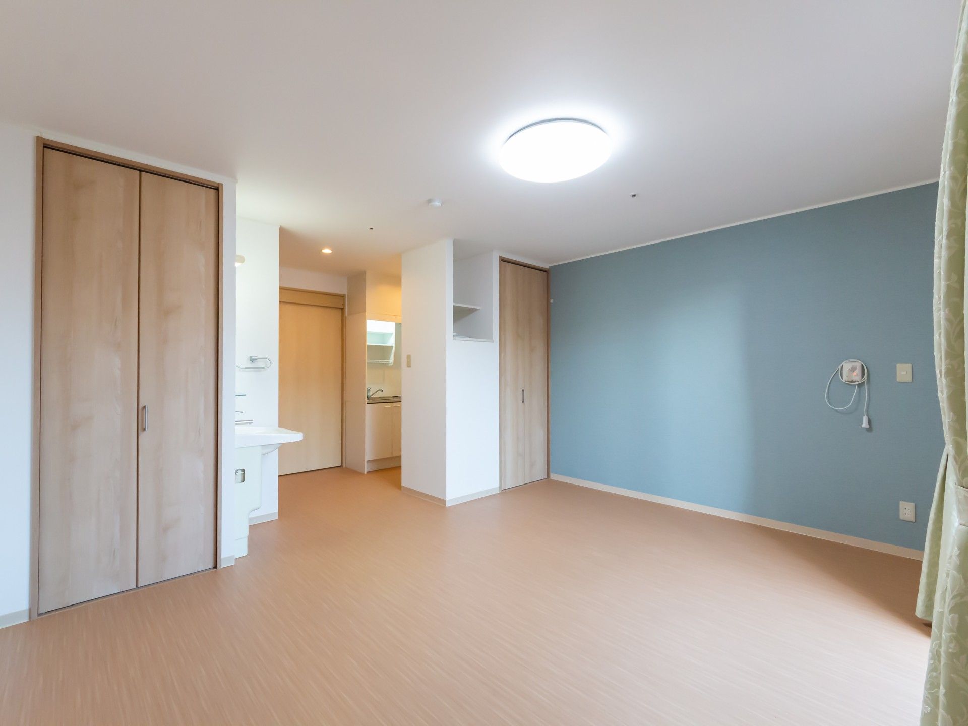 車椅子に乗っている高齢女性と手を差し伸べる女性ヘルパー