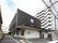 3階建ての建物にはベランダが付き、玄関の周りには点字ブロックが敷かれ、駐車スペースもある。