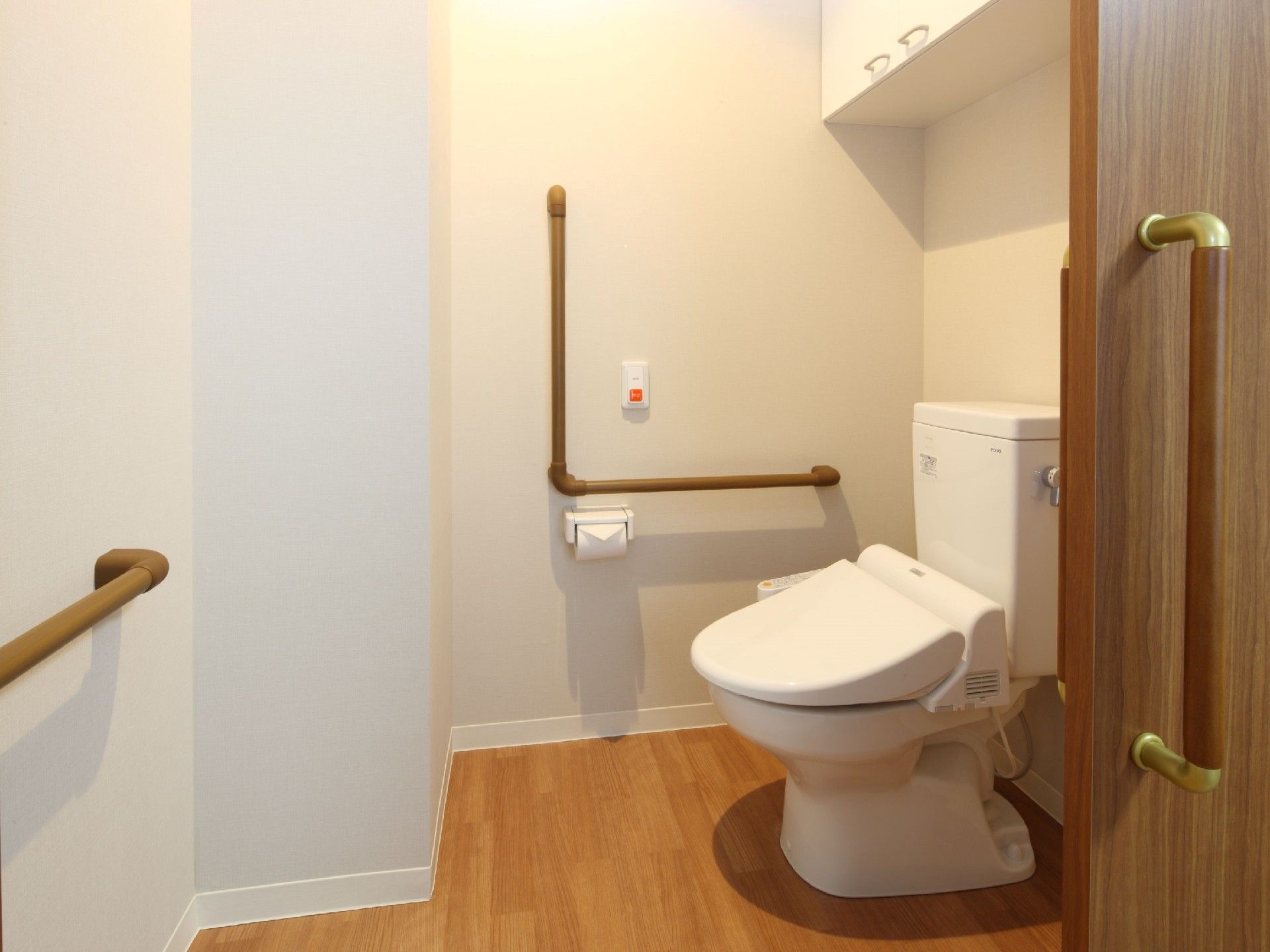 呼び出しボタンがついたトイレにはエル字型の手すりがあり、引き戸で介助スペースも広い。