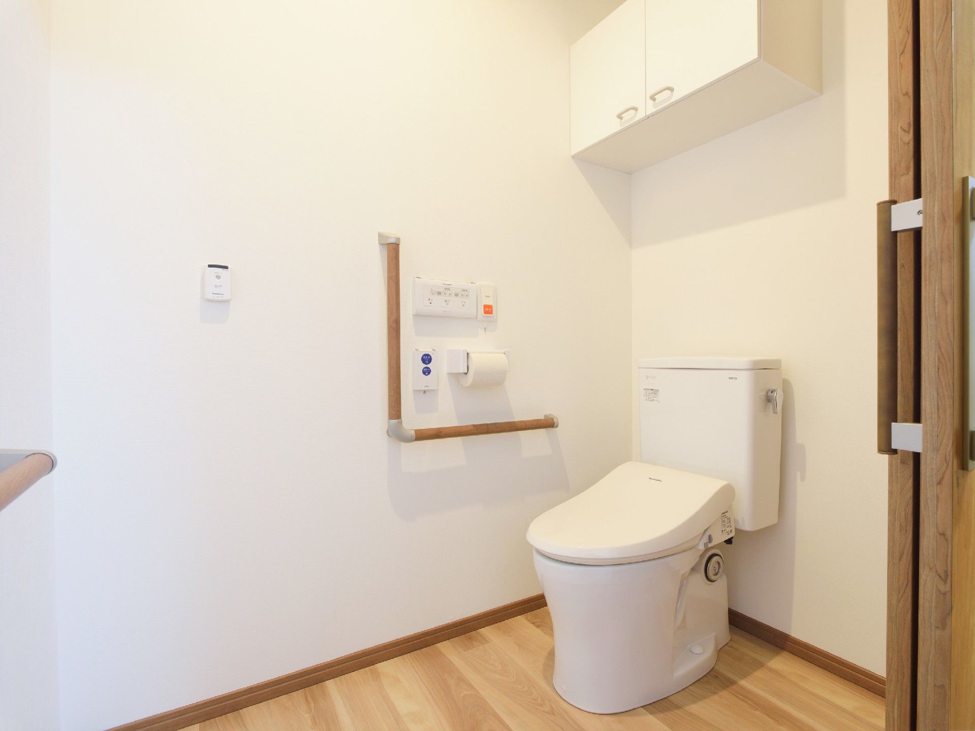 広いトイレにはエル字型の手すりが壁につき、呼び出しボタンもある。収納スペースも設置されている。