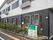 2階建ての建物。1階部分はダークグレー、2階部分は白で、看板もある。