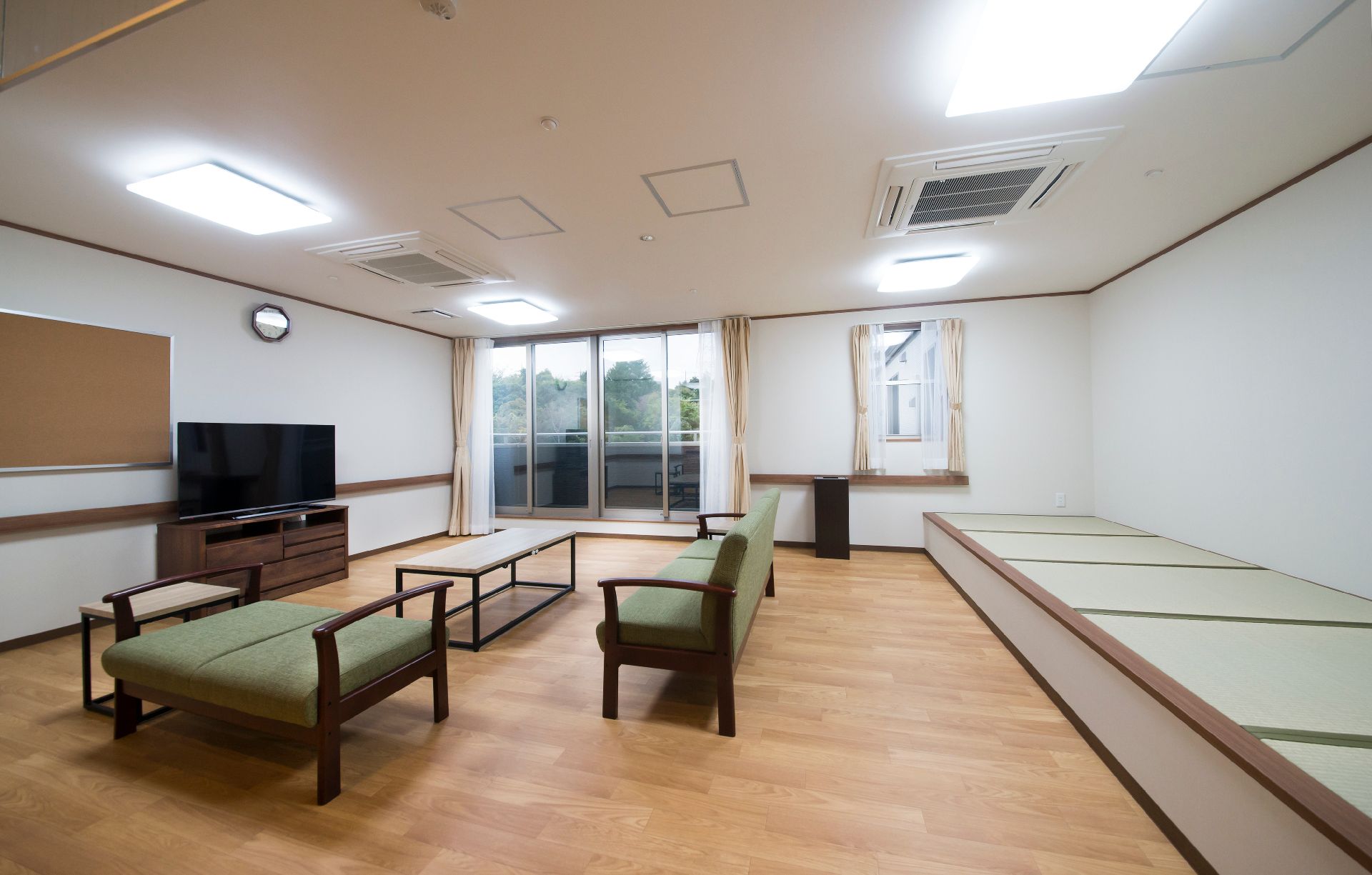大型テレビの前にはソファやテーブルが置かれ、大きな窓からは明るい日差しが降り注いでいる。