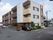 施設は落ち着いた色合いの3階建ての建物であり、閑静な住宅街にほどよく調和している。建物の入口側の空間は駐車や駐輪のために使用されている。