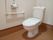 個室内に洋式トイレが設置されており、上部には手洗い場が設けられている。壁には、Ｌ字型の手すりがかかっている。
