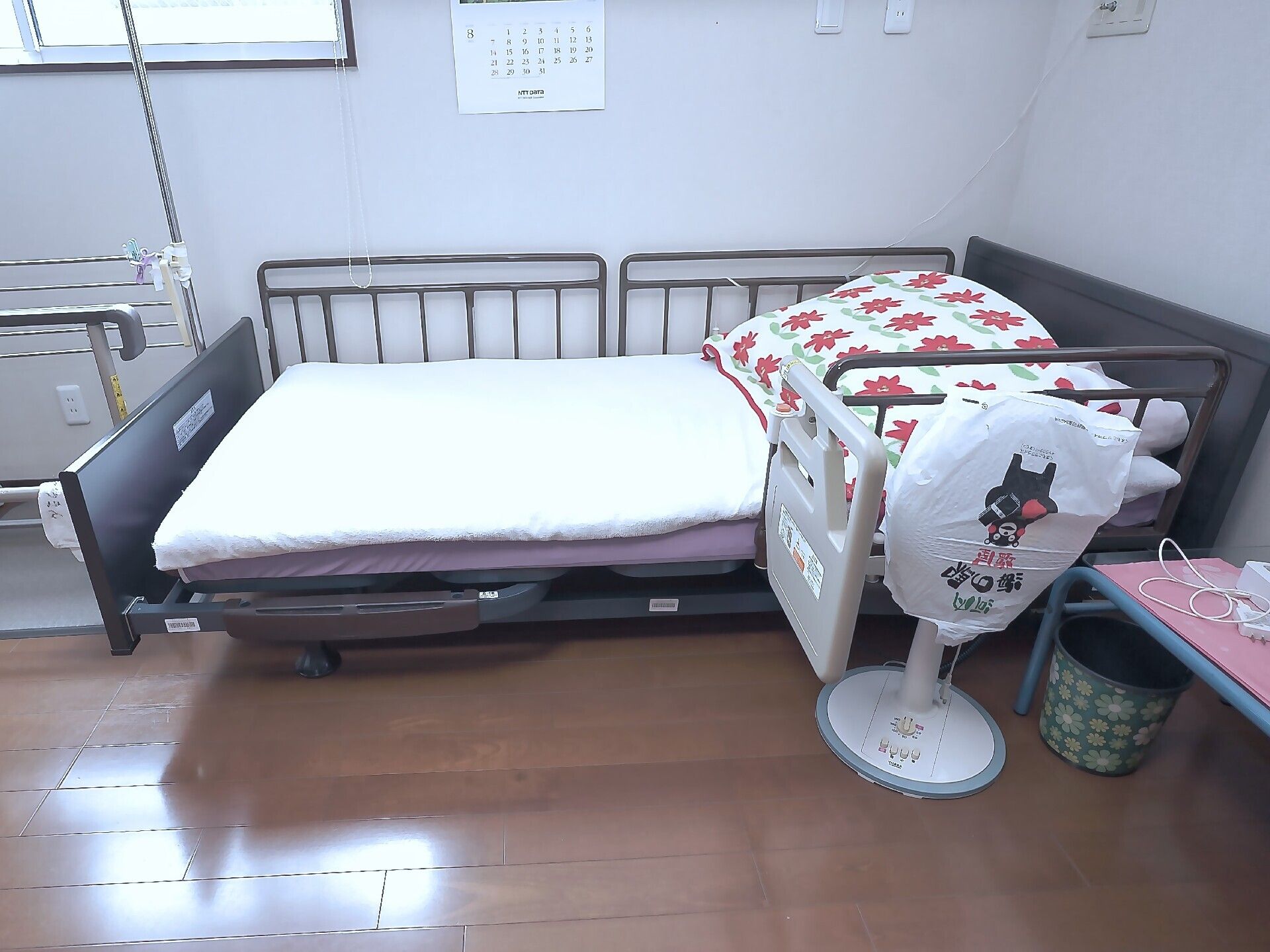 原っぱのような場所をエプロンを付けた女性スタッフに付き添われて歩いている高齢女性。女性はブラウンのジャケットを着て、スタッフに微笑みかけている。