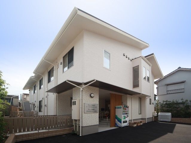 玄関先に自販機が設置されている2階建ての建物