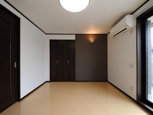 シンプルな居室には家具は置かれておらず、エアコンや大きな窓が付いている。