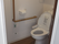 呼び出しボタンが設置されたトイレ内にはエル字型の手すりがあり、洋式のトイレがある。