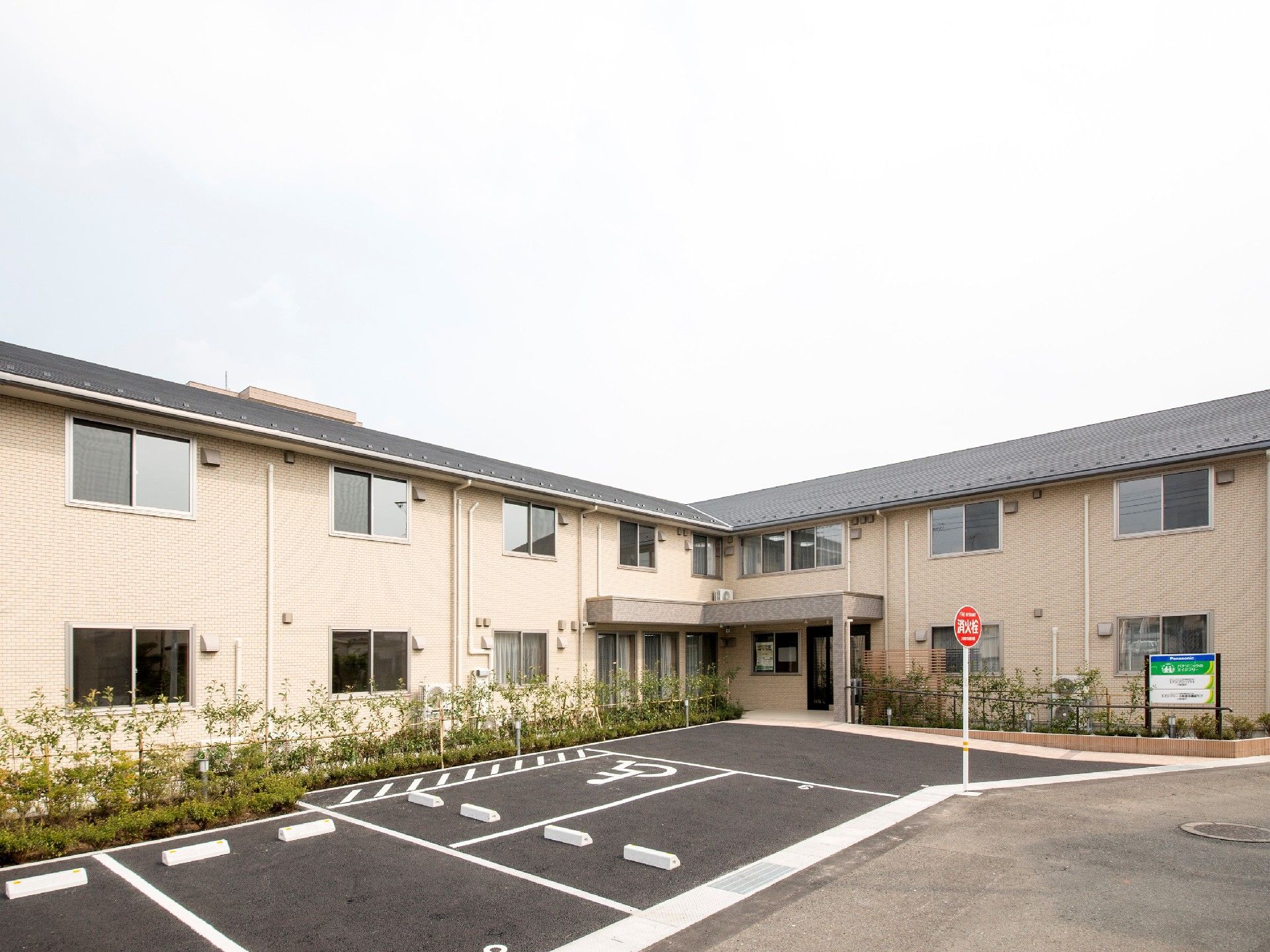 2階建ての建物の前には駐車場があり、建物の周辺には木が植えられ、アットホームな雰囲気。
