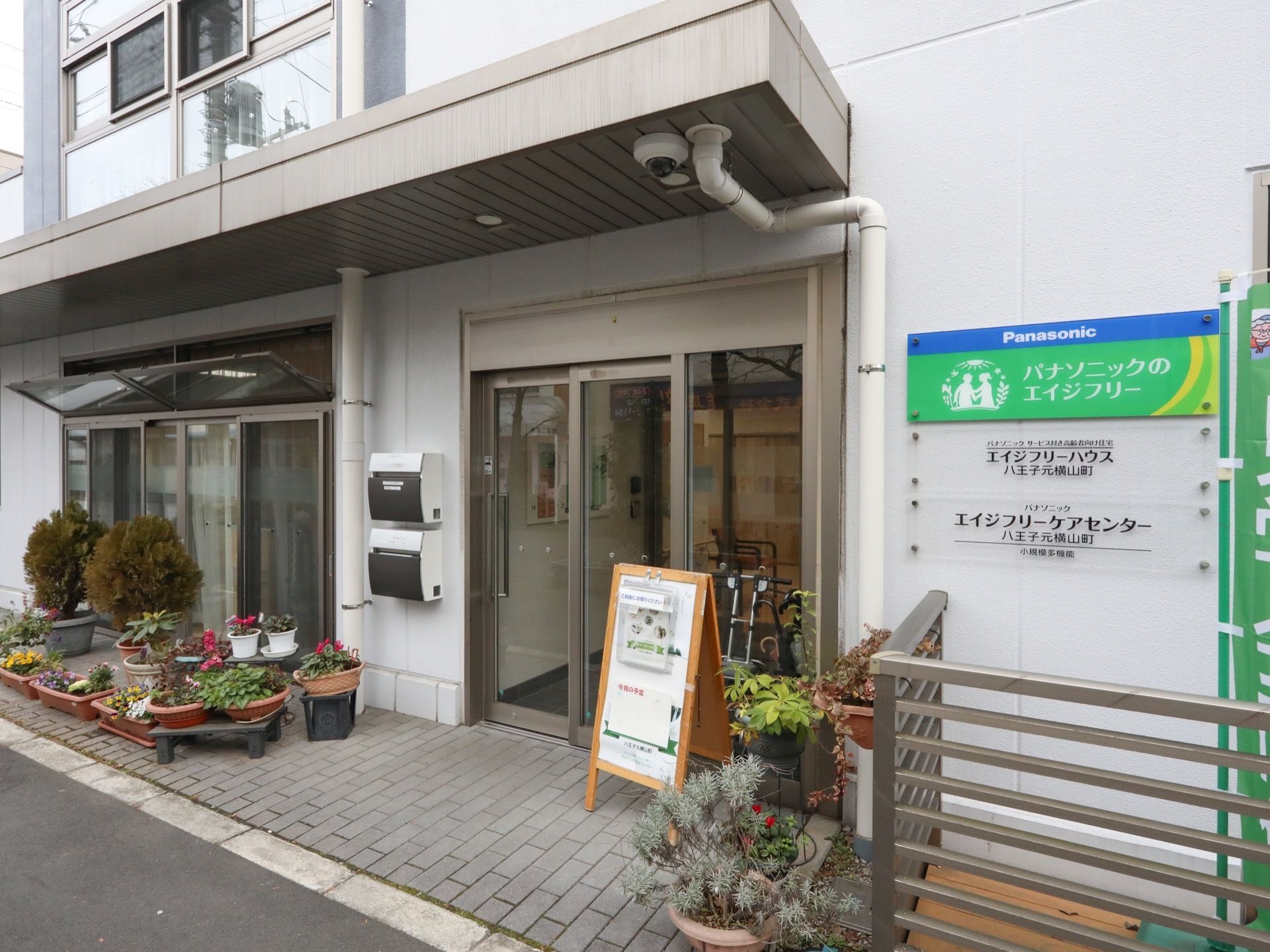 エントランスは奥まった造りで、ドアは２重構造になっている。ドアのそばには、多種多様な植物の植木が並べられて華やかな印象。