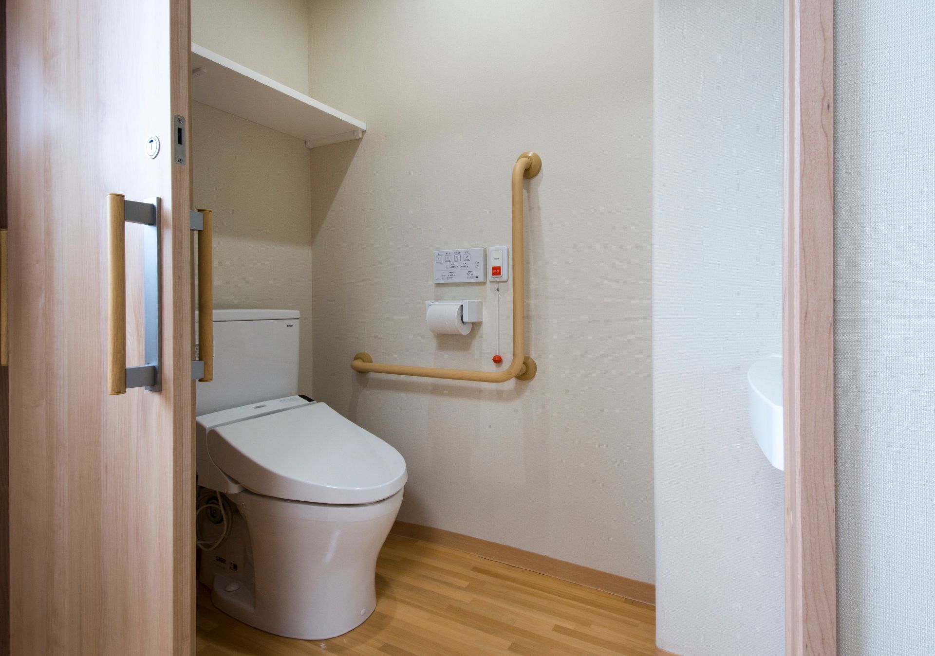 棚が付いたトイレには手すりや呼び出しボタンもあり、引き戸で開け閉めが楽。