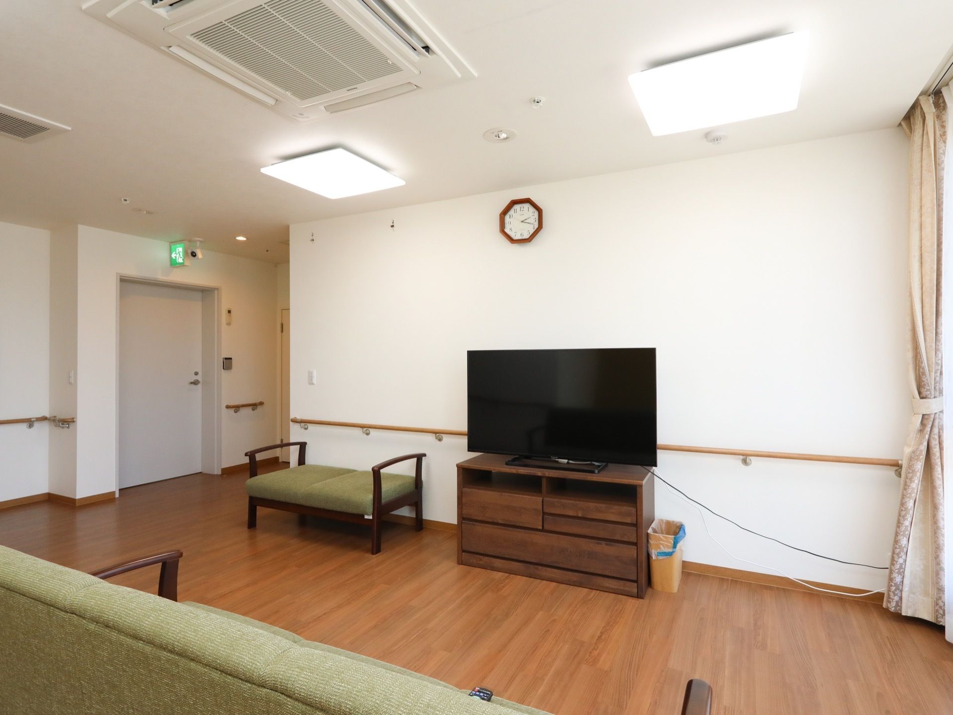 廊下の一角に、ソファーやテレビが用意されたスペースがある。テレビの置いてあるラックの横には、ゴミ箱がある。