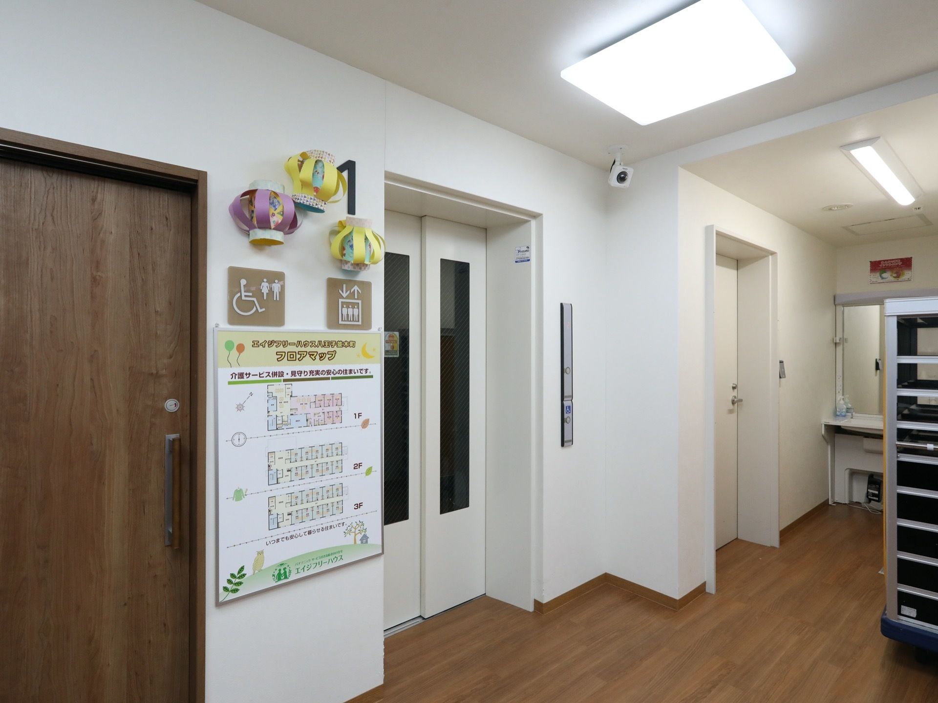 エレベーターとトイレの間の壁には、フロアマップが貼られている。その上には、トイレやエレベーターのイラストが描かれたプレートがある。