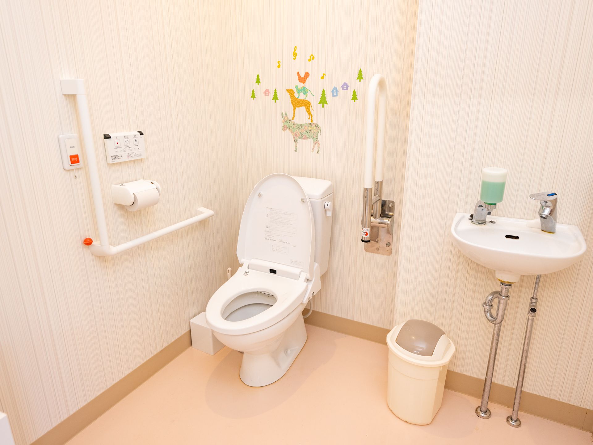 高齢者でも楽に座ることが可能な、手すりのついたトイレ