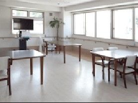 大きな窓が付いた共有スペースには大小のテーブルやテレビが設置されている。