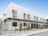 白を基調とした横に長い２階建ての建物は日当たりのいい場所に建っていて、建物の周りには草木が植えられている。