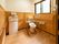 木目調を多く取り入れた広いトイレである。壁に沿って手すりが設置され、呼び出しボタンやトイレットペーパーホルダーなどが備えてある。