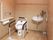 手すりが多く設置されたトイレには手洗い場やタオル掛けがあり、花も飾られている。